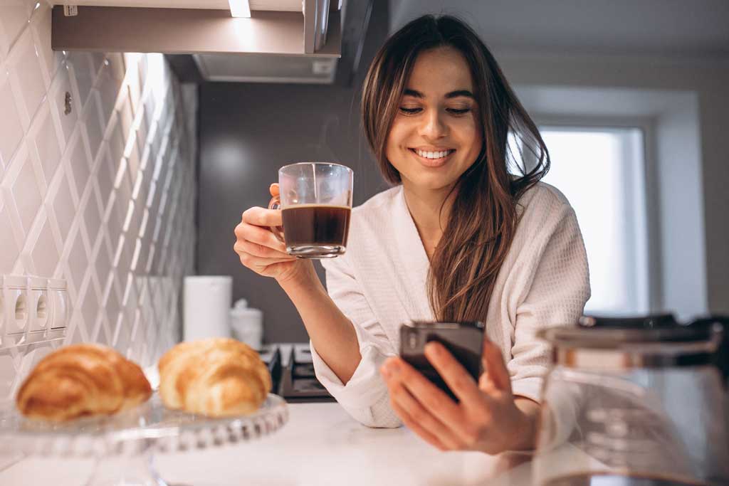 woman s morning with phone croissant coffee kitchen smanjena